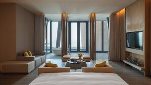 A modern hotel room with a large bed, a sofa, a coffee table, and a TV. - Renaissance Xiamen Hotel (Xiamen)