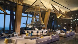 A modern hotel lobby with a bar area, seating arrangements, and large windows offering views. - Renaissance Xiamen Hotel (Xiamen)
