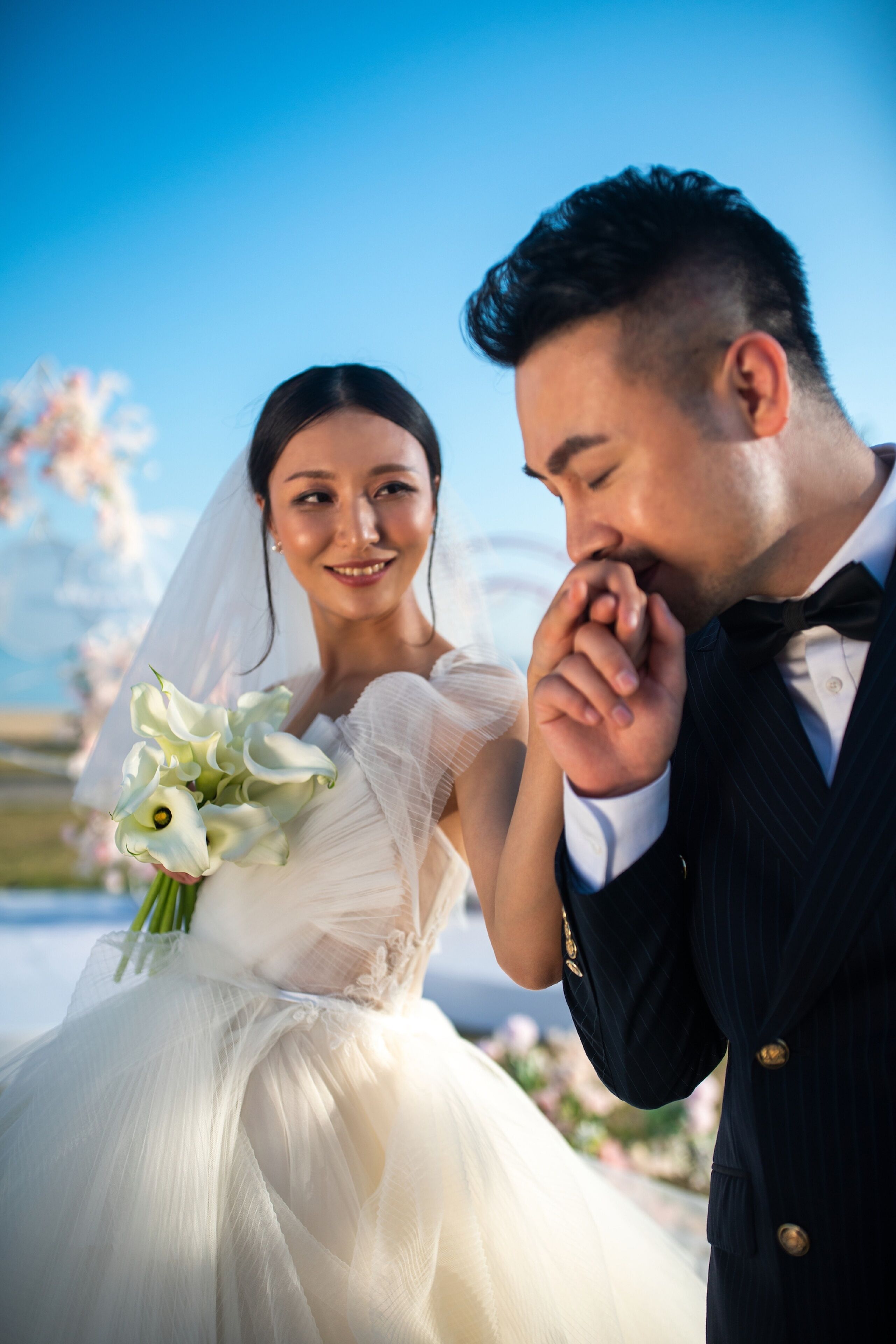 A wedding couple outdoors with a clear sky.