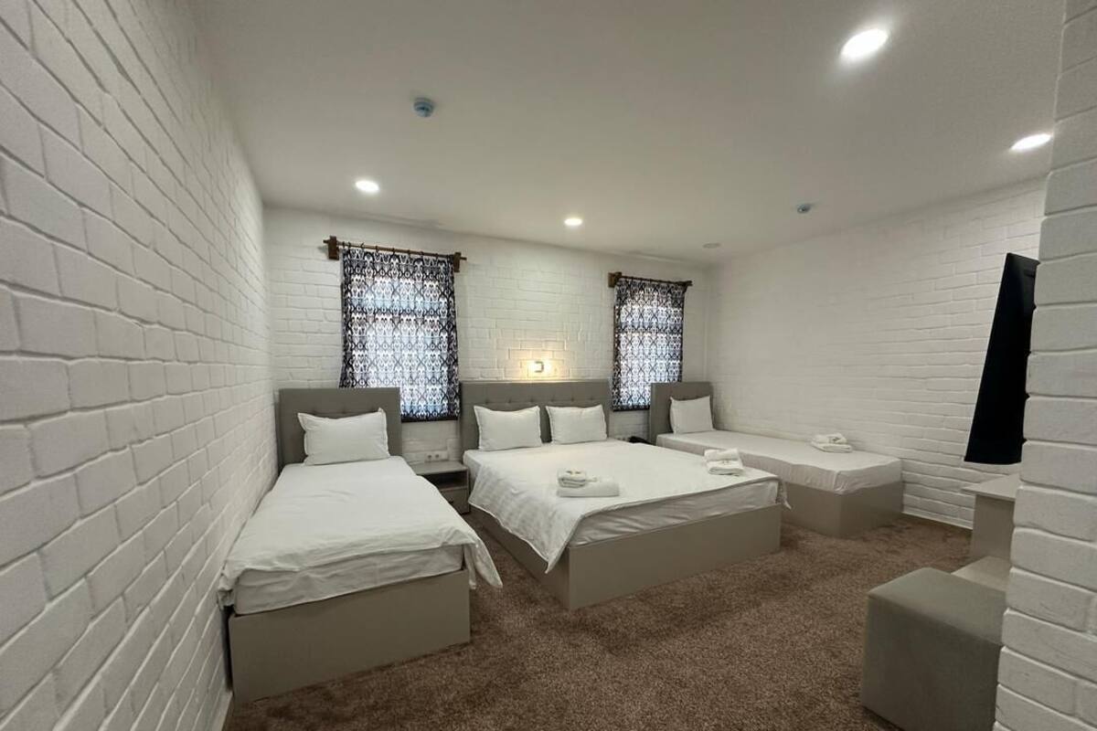 A room with two beds, a small seating area, and a TV.