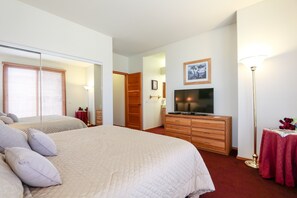 A bedroom with a large bed, a television, a dresser, and a bedside table with a lamp. - Snowcreek V 999 Mammoth Mountain Views, Private Washer Dryer, Pet-Friendly by RedAwning (Mammoth Lakes)