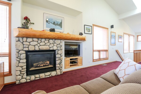 Cozy living room with a fireplace, television, and comfortable seating area.