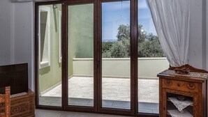 A room with a sliding glass door leading to a balcony. - Mela Villas (Rethymno)