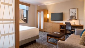 A hotel room with a bed, a desk, a chair, a TV, and a sofa. - Hyatt Place Houston Downtown (Houston)