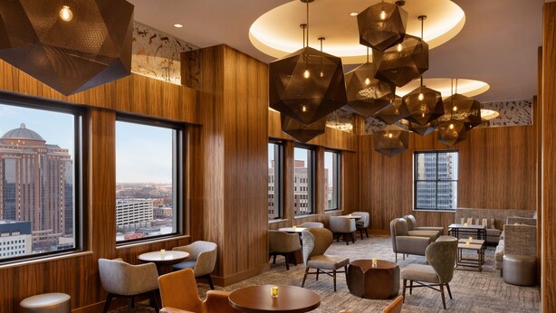 A modern hotel lobby with wooden paneling, multiple seating areas, and large windows offering city views. - Hyatt Place Houston Downtown (Houston)