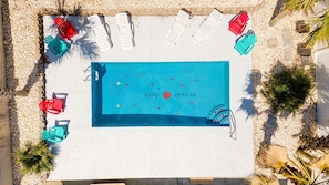 Piscina com espreguiçadeiras e uma placa com a inscrição 'SAND DOLLAR'.