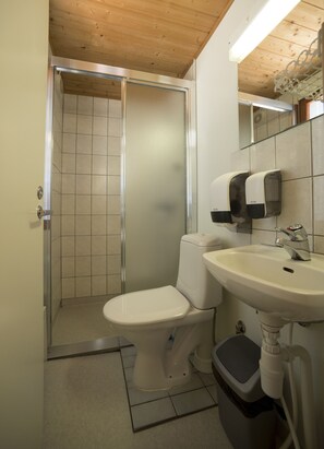 Un baño pequeño con inodoro, lavabo y cabina de ducha.