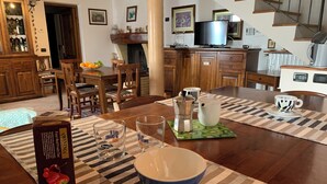 A dining area with a wooden table, chairs, and a coffee maker. - Villa Stefano lake view (Gargnano)