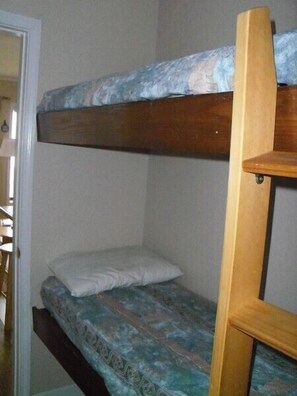 Un lit superposé avec un matelas à motifs et une structure en bois.