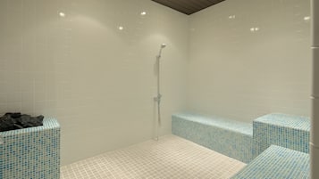 A modern bathroom with white tiled walls, a wooden ceiling, and a shower area with blue mosaic tiles.