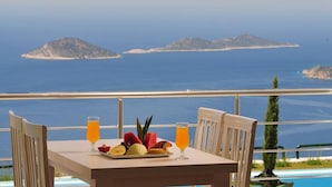 A table with fruit and juice, overlooking a pool and the sea. - Villa Bethany (Kalkan)