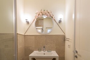 A bathroom with a round mirror, a sink, and a shower. - Villa Mel (Kalkan)