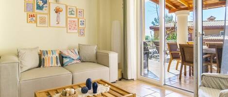A living room with a sofa, coffee table, and artwork on the wall.