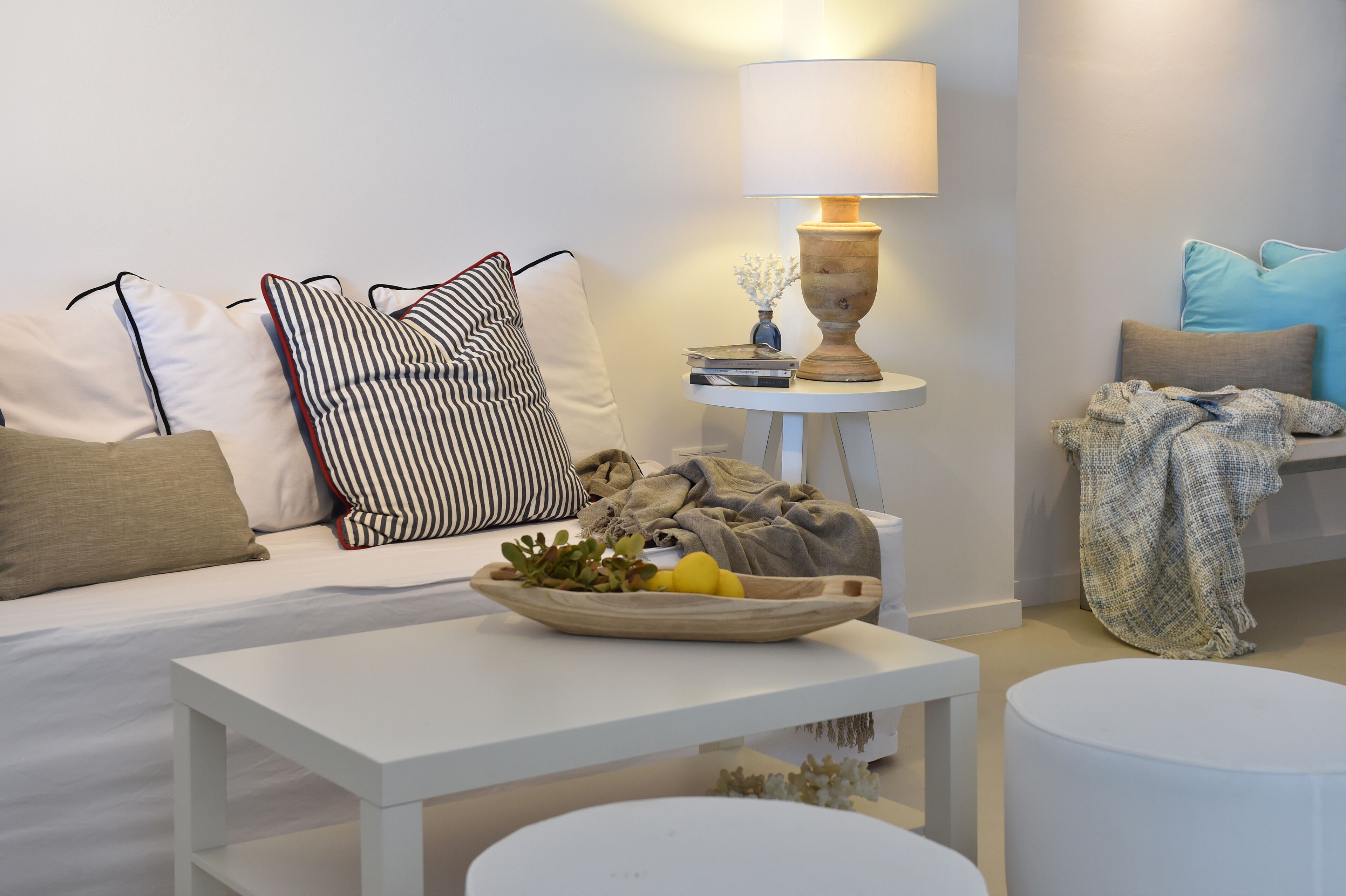 Een moderne woonkamer met een bank, een salontafel, een lamp en een bijzettafeltje.