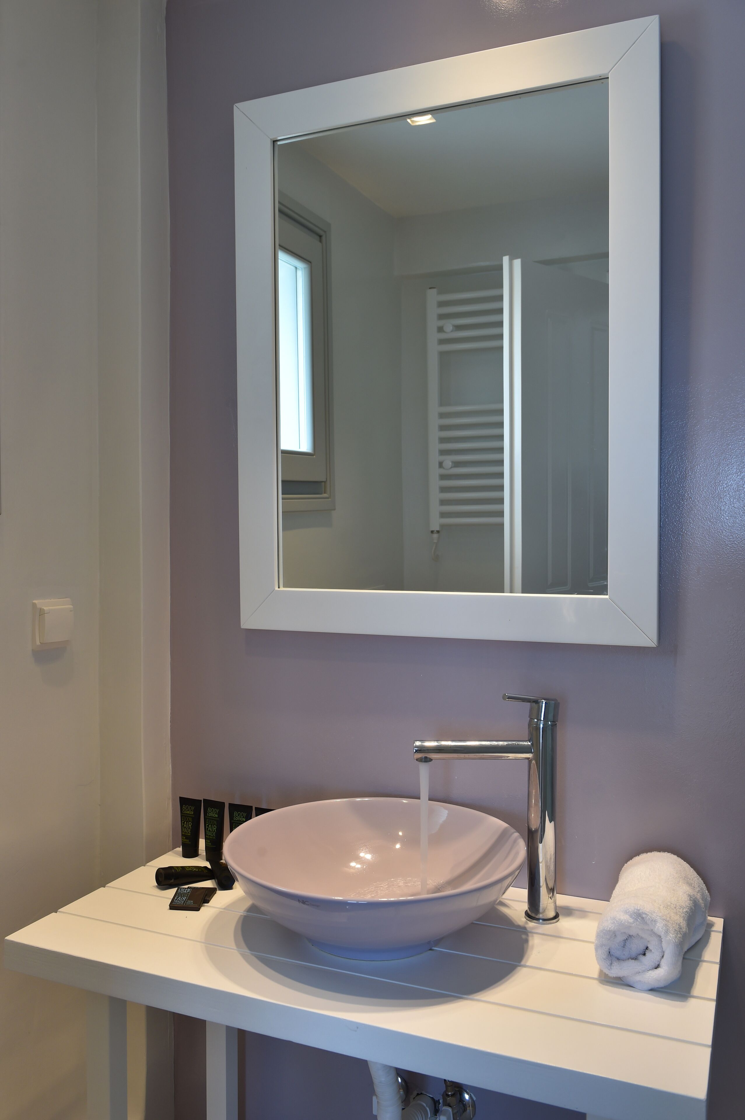 A bathroom with a white sink, a mirror, and a towel.