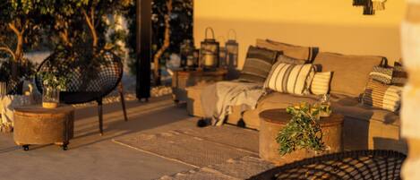 An outdoor seating area with a sofa, chairs, and a coffee table.