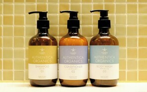 Tres botellas de productos Authentic Organics: champú, acondicionador y gel de ducha.