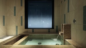 Un baño moderno con un espejo grande, un lavabo integrado y una zona de ducha.