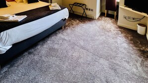 Un dormitorio de hotel acogedor y de una sola habitación, con cama, escritorio, silla y televisión.