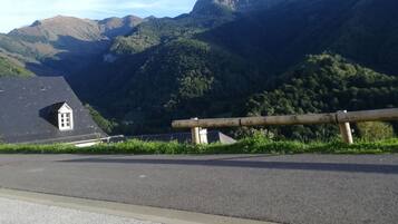 Eine Berglandschaft mit einer Straße und einem kleinen Gebäude mit schrägem Dach.