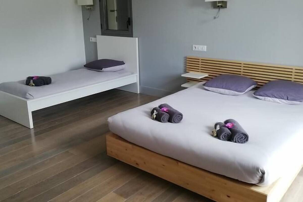 Habitación triple familiar | Espacio para trabajar con un portátil y cortinas opacas