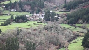 Een landelijk landschap met terrassen en een groot huis, omringd door bomen.