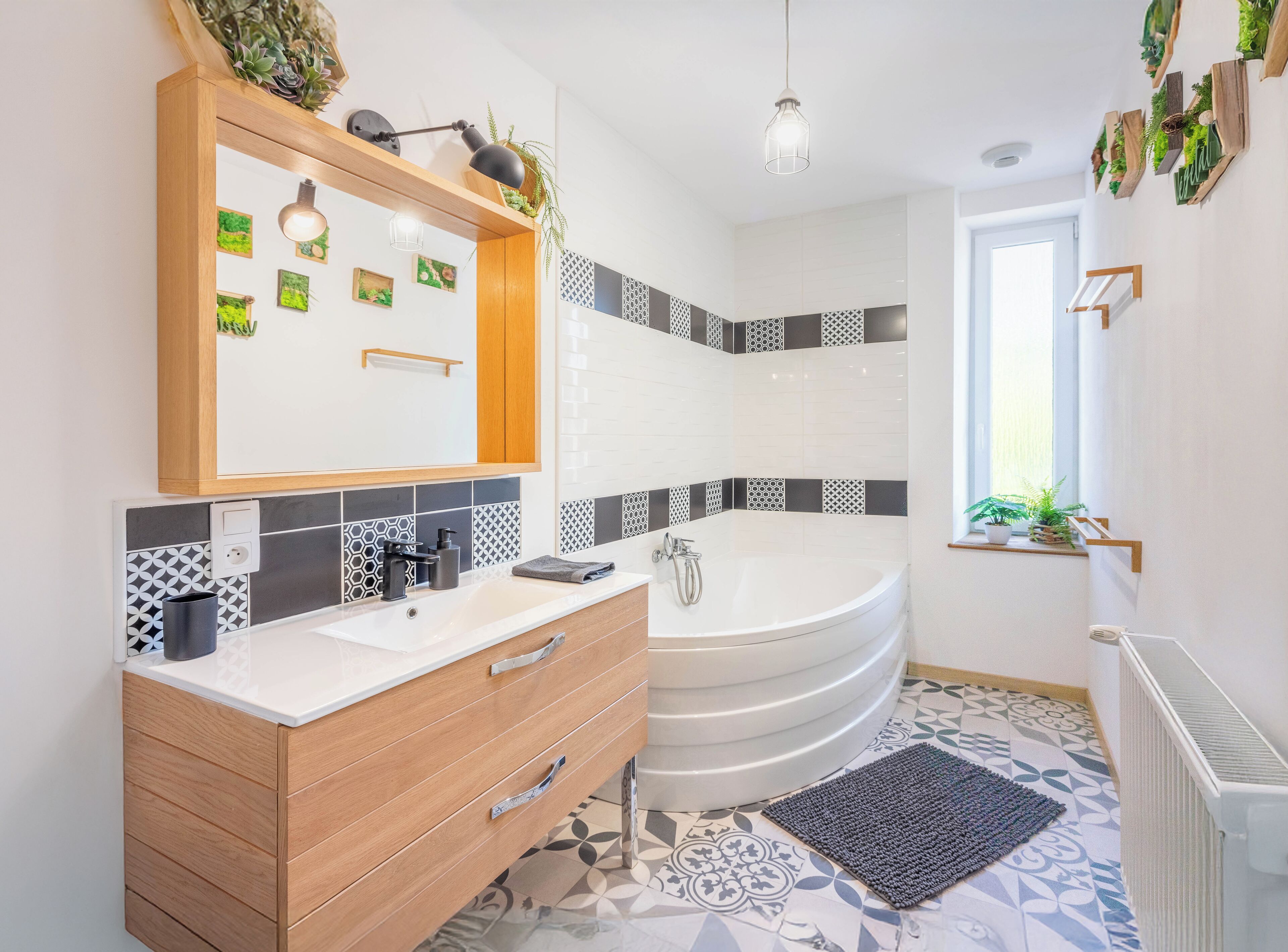 A modern bathroom with a wooden vanity, a large bathtub, and patterned tiles.