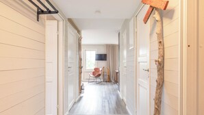 A hallway with a wooden floor, white walls, and a door at the end. - Åre Travel- Mitt i Åre 2 (Are)