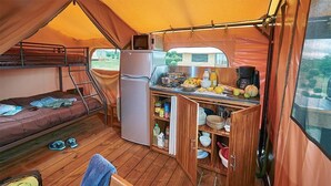 A compact kitchen with a refrigerator, microwave, and a small dining area.