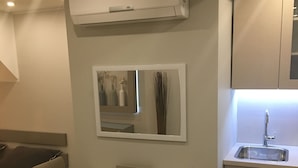 A compact kitchen with a built-in sink, a mirror above the countertop, and an air conditioning unit mounted on the wall. - D&G Apartments Zagreb  (Zagreb)