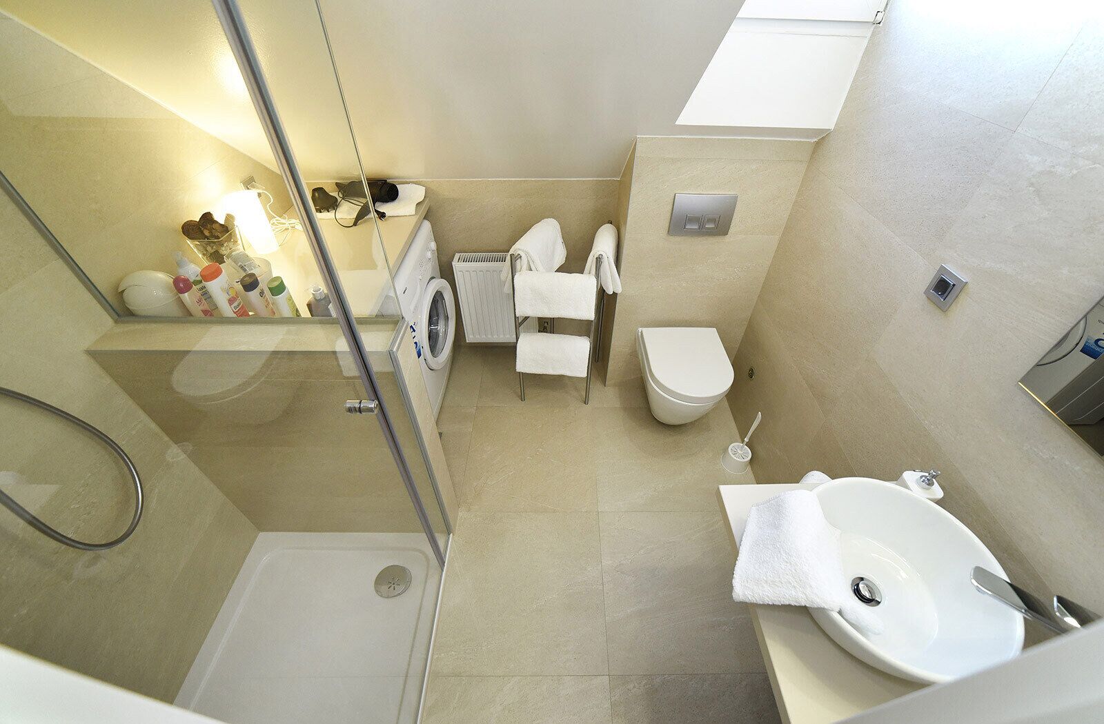 Un bagno d'albergo compatto con doccia, servizi igienici e lavandino.