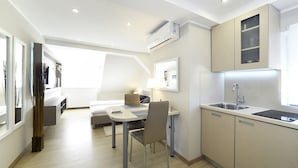 A modern kitchen with a dining area, a built-in oven, and a window overlooking the room. - D&G Apartments Zagreb  (Zagreb)