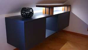 A modern, built-in desk with a dark finish, a decorative black vase, and a wooden shelf. - D&G Apartments Zagreb  (Zagreb)