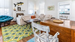Una sala de estar amplia con un conjunto de sofás, una mesa de centro y un comedor con una mesa de madera y sillas.