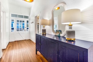 Stylish hallway with a large mirror, two lamps, and a cabinet.