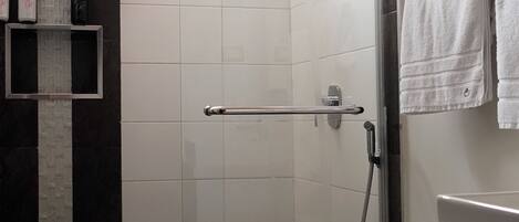 A modern bathroom with a shower, toilet, and a vanity with a mirror.