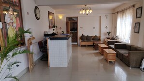A spacious living area with a central island, sofas, and a reception desk. - Thori Resort (Thimphu)