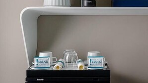 Eine Minibar mit Kühlschrank, Getränken und einer Kaffeemaschine.