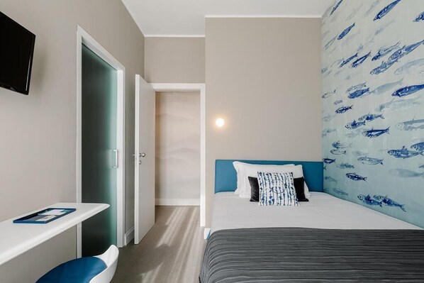 Une chambre d’hôtel avec un lit, un bureau et une chaise.