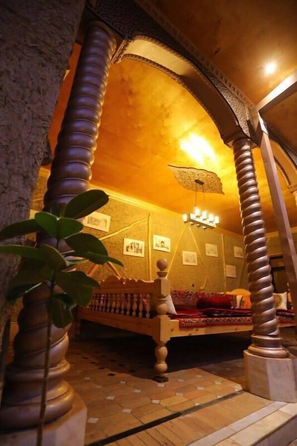 Una habitación con cama, candelabro y planta.
