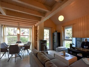 Relax in this open living space with a sofa, dining area, and TV, offering a perfect spot for unwinding and socializing.
