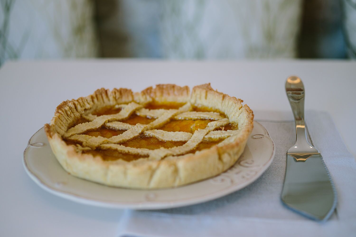 Une tarte sur une assiette, avec une spatule à tarte à côté.