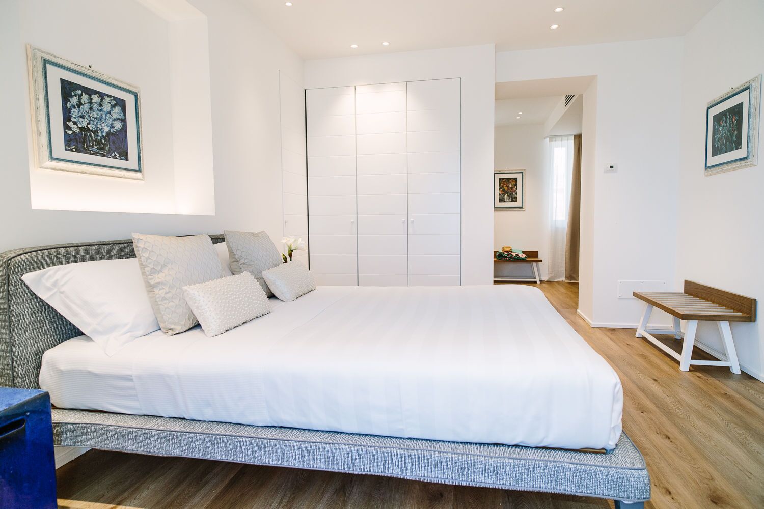 Una camera da letto moderna con un letto grande, un armadio e una panca.