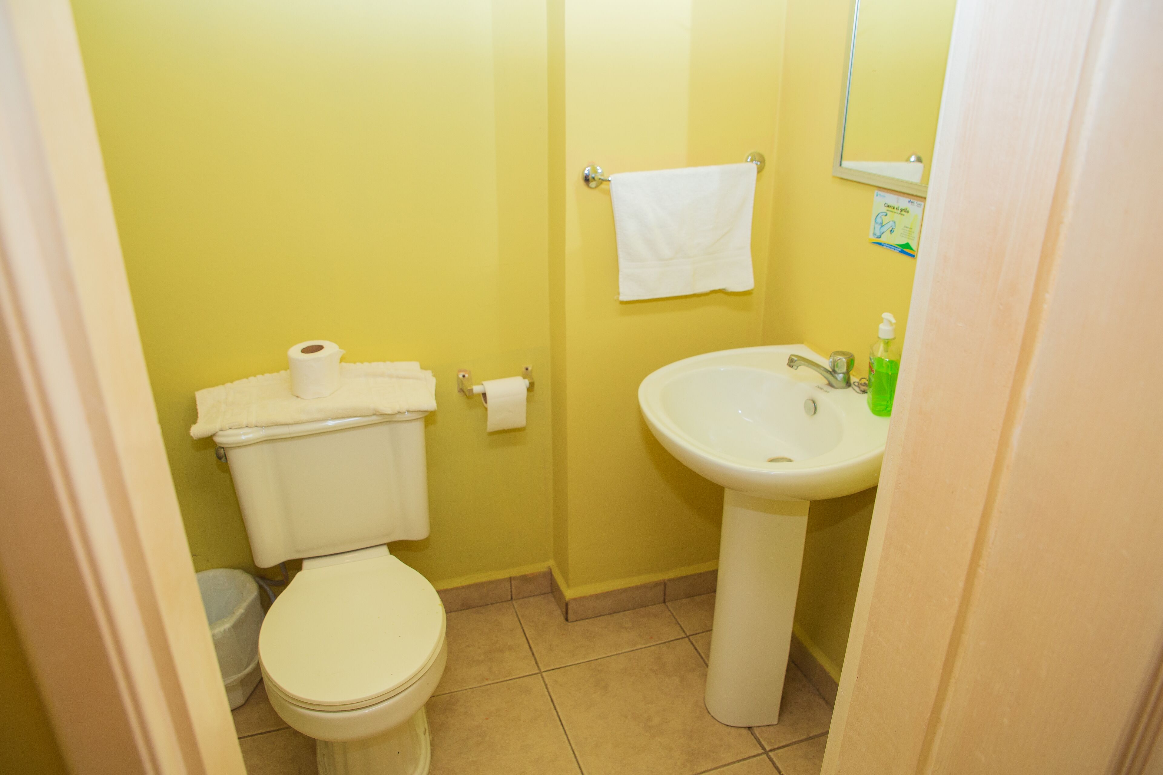 Une petite salle de bain avec des toilettes, un lavabo et une serviette accrochée au mur.