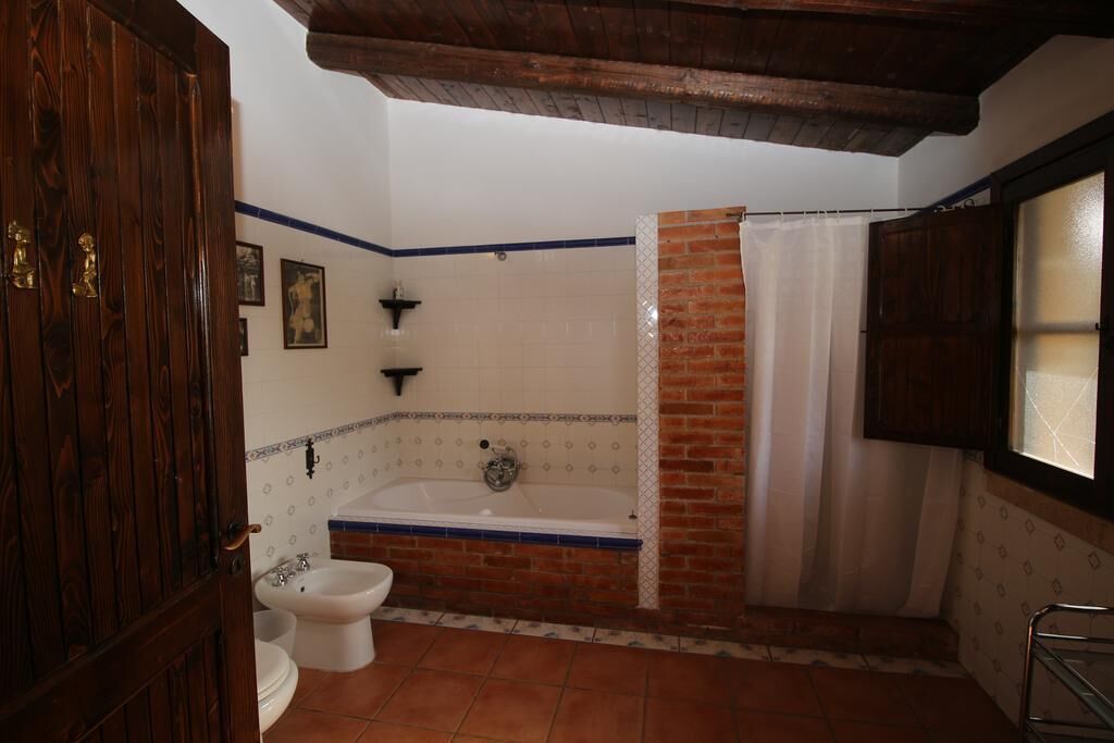 A bathroom with a bathtub, a toilet, and a shower curtain.