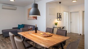 Een moderne eetruimte met een houten tafel, stoelen en een hanglamp.