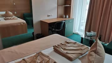 Une chambre d’hôtel avec deux lits, un bureau, une télévision et un miroir.