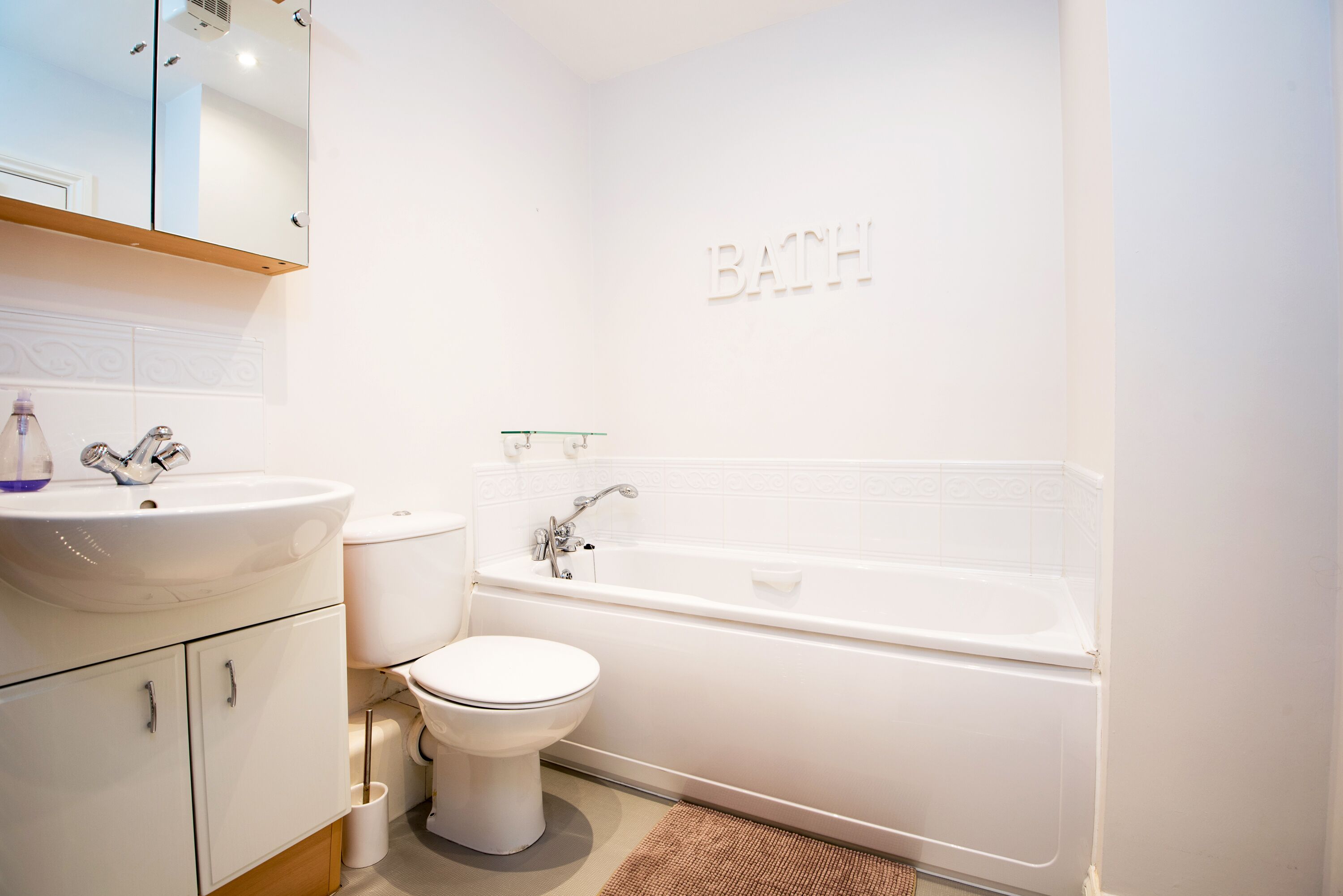 A bathroom with a sink, toilet, and bathtub.