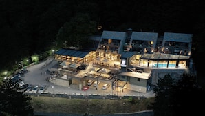 A multi-story hotel with a swimming pool, outdoor seating, and a parking area. - Panorama Hotel & Spa (Krusevo)
