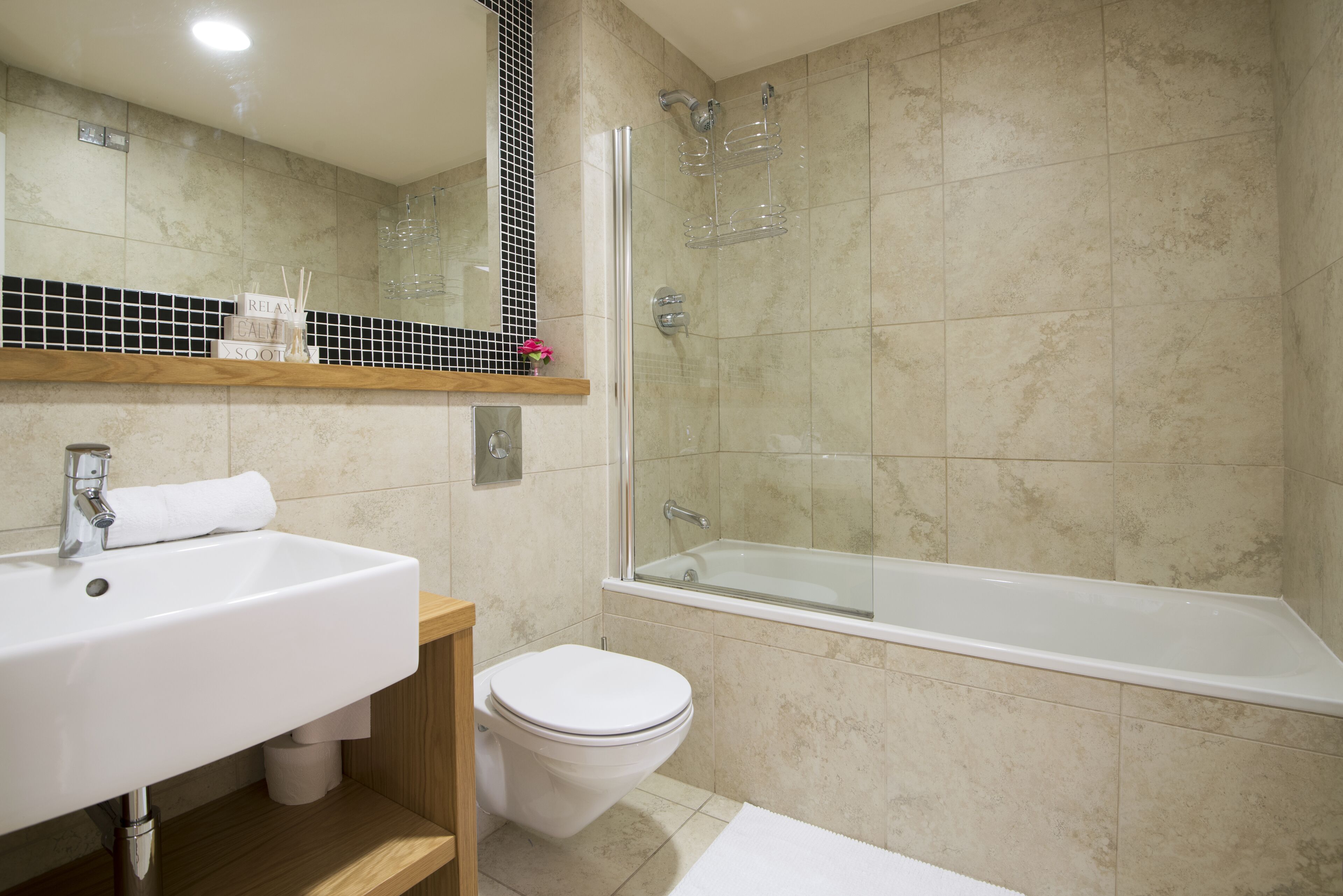 A bathroom with a white sink, a toilet, a bathtub, and a shower area.